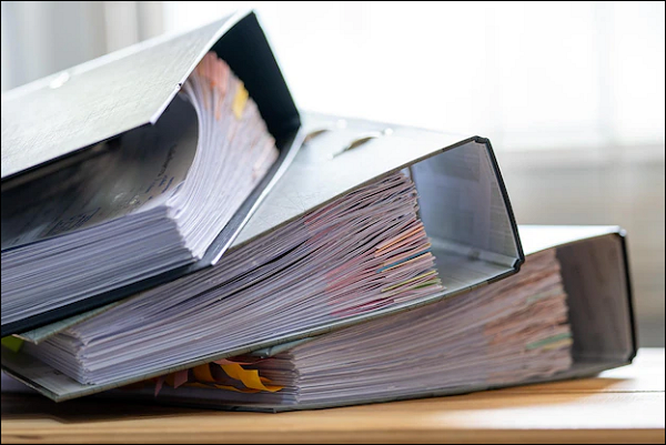 three lever arch files packed full of paperwork