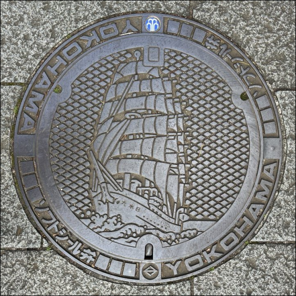manhole cover - Nippon Maru sailing ship design - natural metal